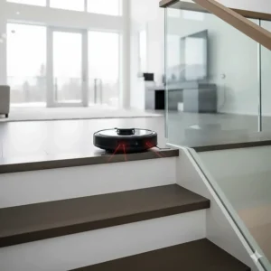 Illustration of a robot vacuum using cliff sensors to safely navigate the top of a staircase in a multi-level home.