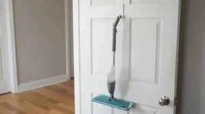 flat mop vs spin mop for small apartments hanging on a wall hook behind a door