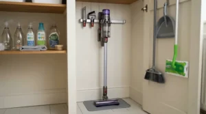 A microfibre dust mop for hardwood floors stored neatly alongside other cleaning supplies in a utility closet.